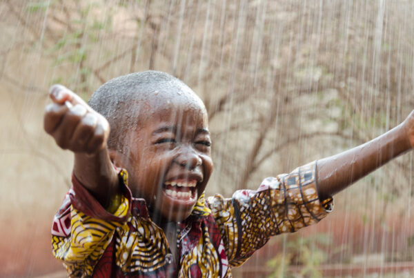 Laughing little boy in the rain