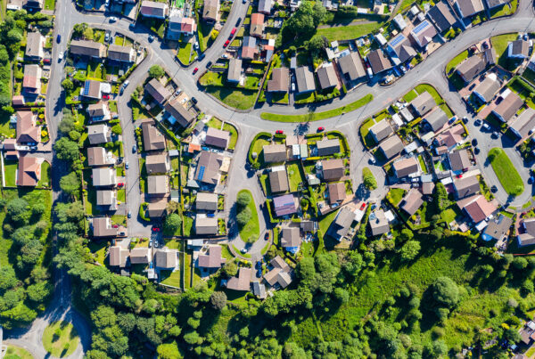 Drone wide view of american new suburb at summertime. Establishing shot of neighborhood. above aerial footage