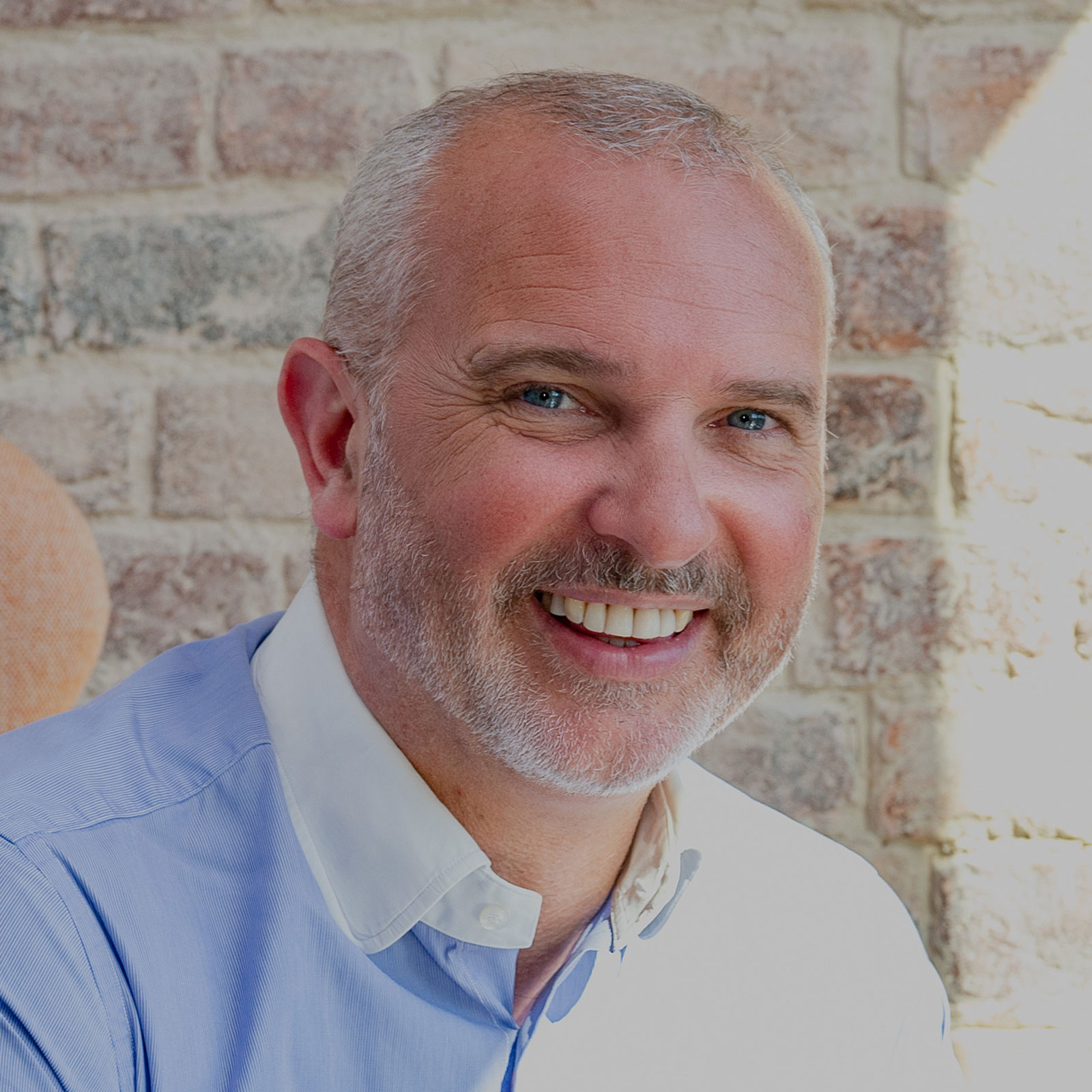 K2 CEO Nick Plummer smiling in front of brick wall