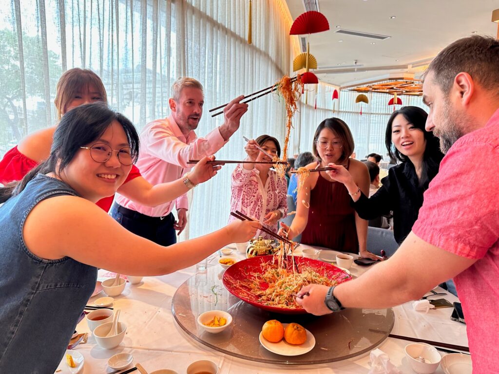 K2 Singapore team celebrating and tossing Yusheng