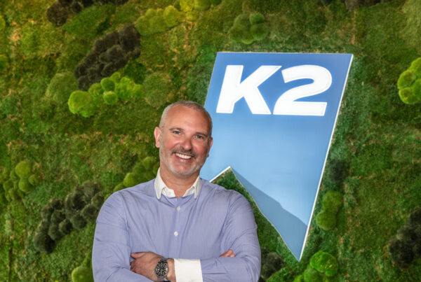 Nick Plummer in front of K2 sign and moss wall