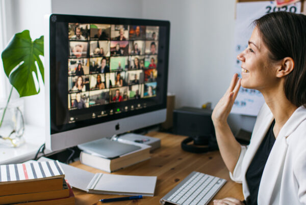 Smiling and waving lady on a video conference call