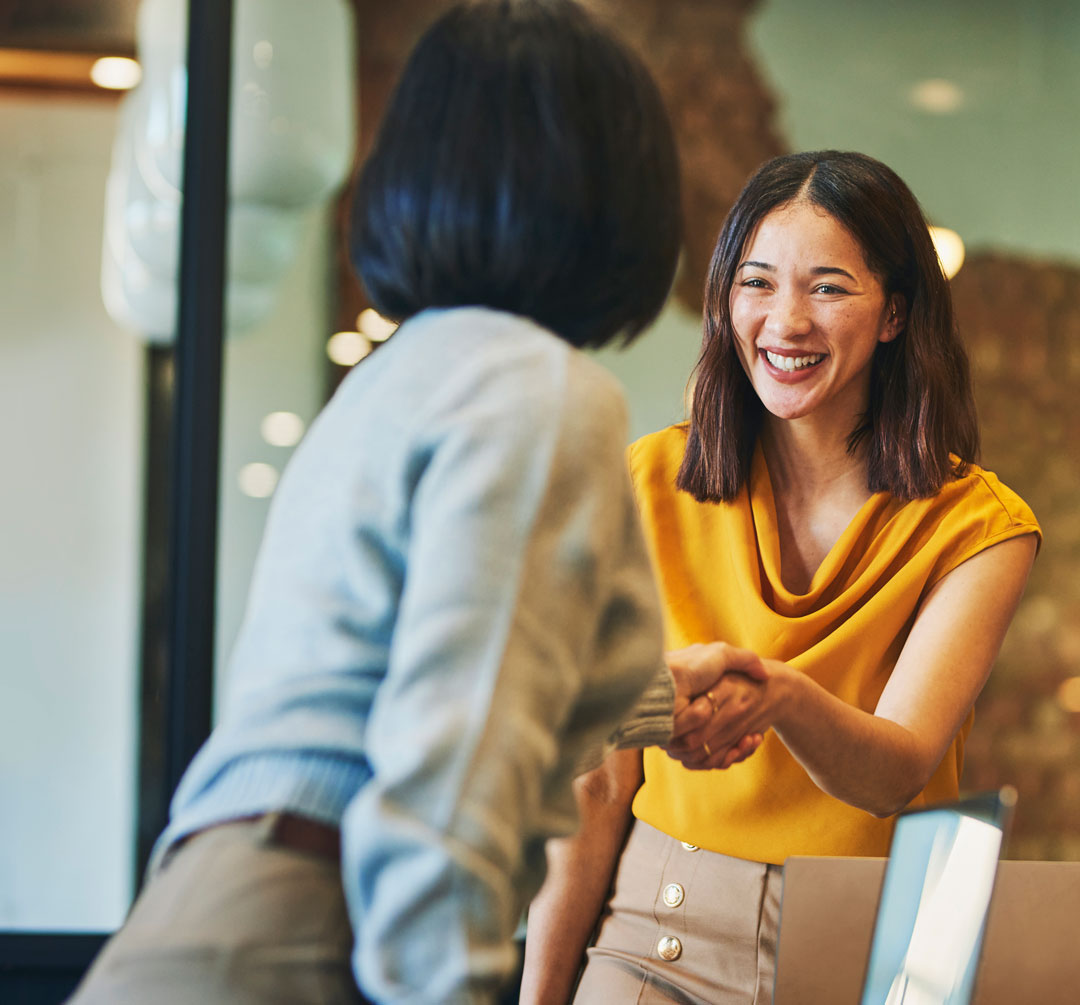 Two business women shaking hands